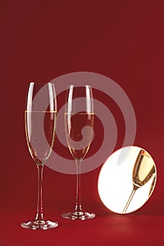 Stylish glasses of champagne on a stand on a red background