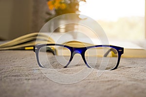 Stylish glasses closeup and blured book.