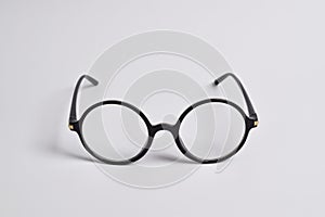 Stylish glasses with round black frames on white background