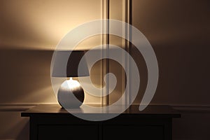 Stylish glowing night lamp on table in room. Space for text