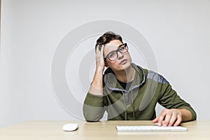 Stylish good-looking caucasian man keyboarding on computer while working on on new project, having focused, concentrated and tired