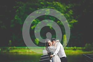 Stylish gorgeous happy brunette bride and elegant groom on the p