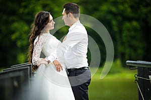 Stylish gorgeous happy brunette bride and elegant groom on the p