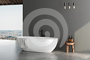 Stylish gray bathroom interior with white bathtub, concrete floor, window with city view, dark wall, white bathtub. 3 d rendering