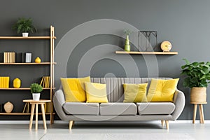 Stylish grey sofa with yellow pillows near green wall with wooden book shelf. Scandinavian interior design