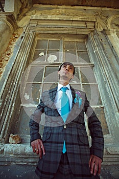 Stylish groom on background old renaissance window