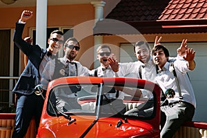 Stylish groom and his friends in the car