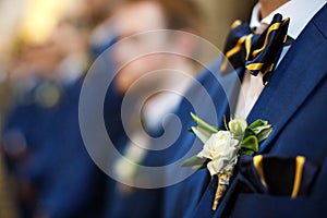 Stylish groomsmen stand during the ceremony in the church