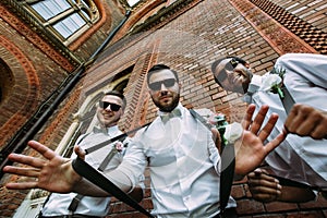 Stylish groomsmen in the sunglasses and bow-ties