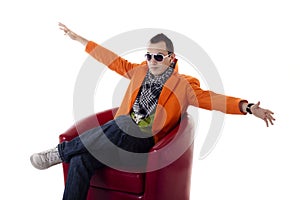 Stylish guy with glasses sitting on a red chair