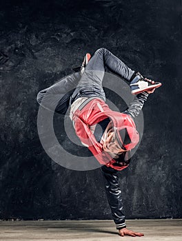 Stylish guy performs breakdance acrobatic elements.