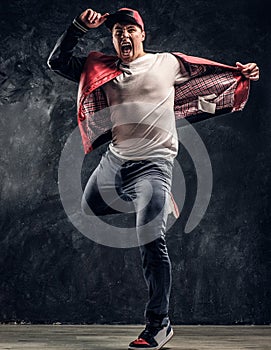 Stylish guy performs breakdance acrobatic elements.