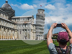 Stylish guy with a phone taking pictures of the Leaning Tower