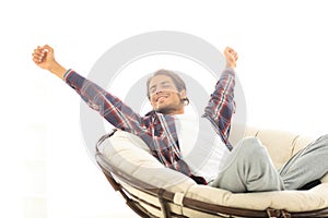 Stylish guy stretching in a comfortable chair