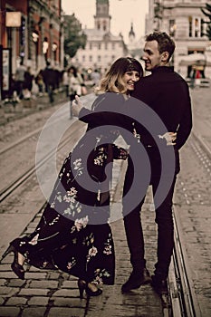 Stylish gypsy couple in love walking and smiling in evening city