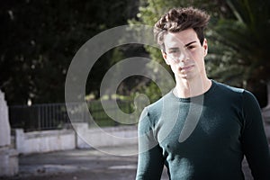 Stylish hair young man outdoors, tight knit intense light