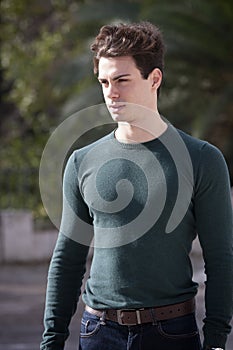 Stylish hair young man outdoors, tight knit intense light