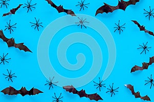 Stylish Halloween design. Bats and spiders on blue background top view copy space frame