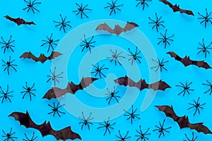 Stylish Halloween design. Bats and spiders on blue background top view pattern