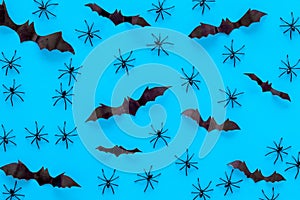 Stylish Halloween design. Bats and spiders on blue background top view pattern