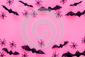 Stylish Halloween design. Bats and spiders on pink background top view space for text frame