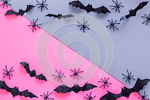 Stylish Halloween design. Bats and spiders on pink and blue background top view copy space