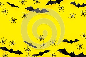 Stylish Halloween design. Bats and spiders on yellow background top view copy space frame