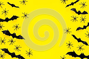 Stylish Halloween design. Bats and spiders on yellow background top view copy space frame