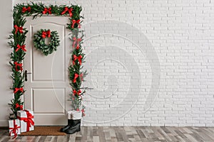 Stylish hallway interior with decorated door and Christmas gifts