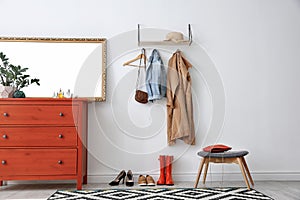 Stylish hallway interior with mirror and chest