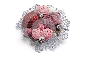 Stylish handmade brooch consisting of pink flowers from fabric on a white background.