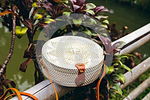 Stylish handmade rattan eco friendly handbag on a tropical background. Bali island.