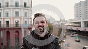 A stylish handsome man with a beard drinking takeaway coffee or tea looking to the side.