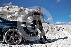 Stylish handsome man posing with car. Elegant young businessman.