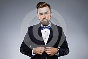 Stylish handsome man wearing a classic suit with bow-tie