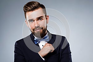 Stylish handsome man wearing a classic suit with bow-tie