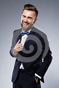 Stylish handsome man wearing a classic suit with bow-tie