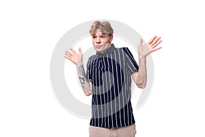 stylish handsome young blond man with tattoos on his arm on a white background