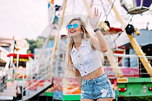 Stylish happy young woman wearing short denim shorts and a white T-shirt. brightred lips . portrait of smiling girl in sunglasses