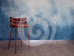 Stylish high chair on the background of the textured wall of blue shade,