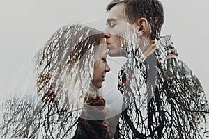 Stylish hipster couple in double exposure with tree branches in