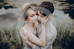Stylish hipster couple hugging at lake. man and woman in modern