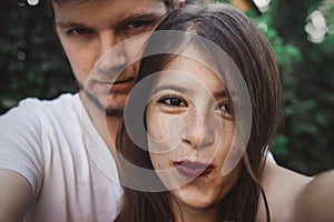 Stylish hipster couple making selfie and embracing. Happy family couple in love making self portrait and smiling in evening summer