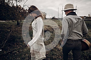 Stylish hipster couple posing. man in hat with guitar and his bo