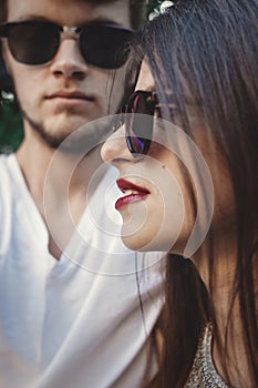 Stylish hipster couple in sunglasses posing and making cool selfie. Happy family couple in love making self portrait and embracing