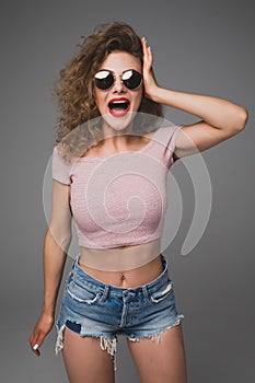 Stylish hipster fashion portrait of trendy casual young woman with scream emotions in studio