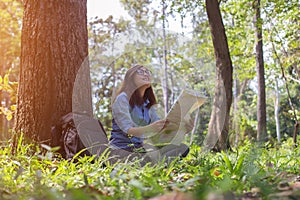 Stylish hipster traveler exploring map at sunny forest and lake in the mountains landscape