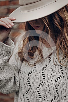 Stylish hipster woman posing in knitted sweater on background o