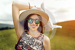 Stylish hipster woman traveler holding map, with fashionable sun