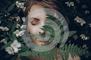 Stylish hipster woman with fern leaf embracing. girl portrait wi
